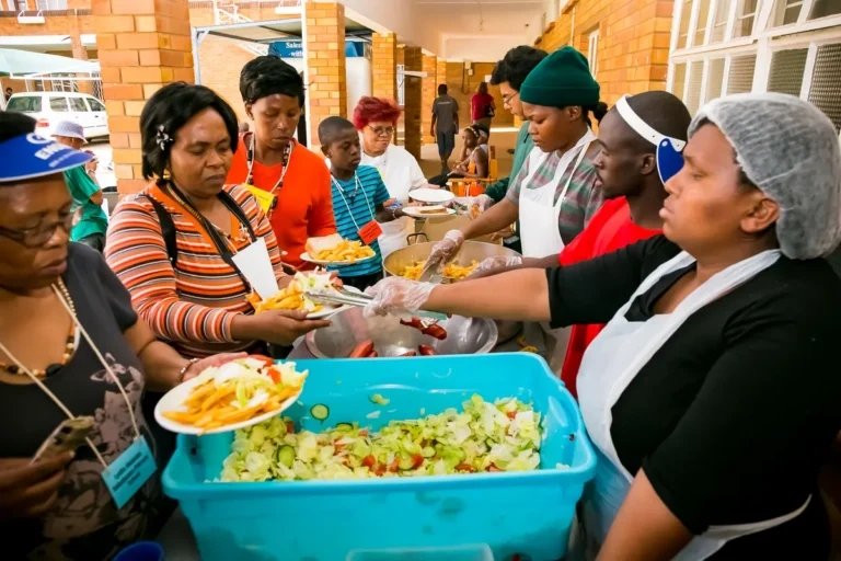 Volunteers serving food to people at a community kitchen