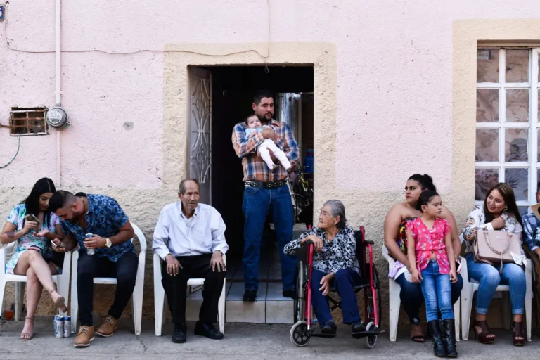 Neighbours of different generations sitting together outside a house